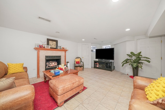 living area featuring light tile patterned floors, recessed lighting, visible vents, and a tile fireplace