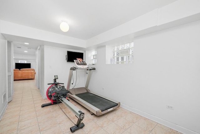 workout area with light tile patterned floors and baseboards