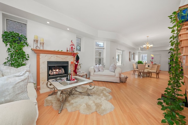 living area with a fireplace, recessed lighting, wood finished floors, and a chandelier