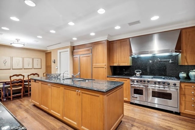 219 E Lake Shore Dr Unit 2Abc, Chicago, IL 60611 - kitchen with high end appliances, wall chimney exhaust hood, a sink, ornamental molding, and light wood-style flooring