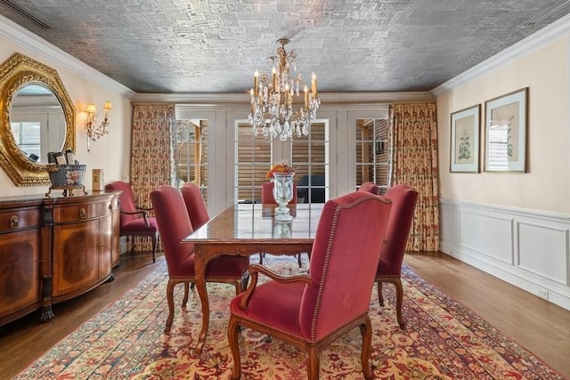 219 E Lake Shore Dr Unit 2Abc, Chicago, IL 60611 - dining room featuring a chandelier, wood finished floors, crown molding, a decorative wall, and a wainscoted wall