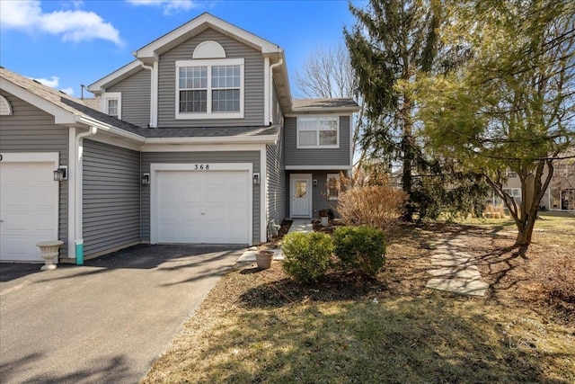 view of front of property with a garage, driveway, and a shingled roof