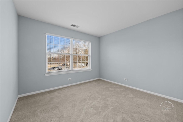 empty room featuring carpet flooring, baseboards, and visible vents