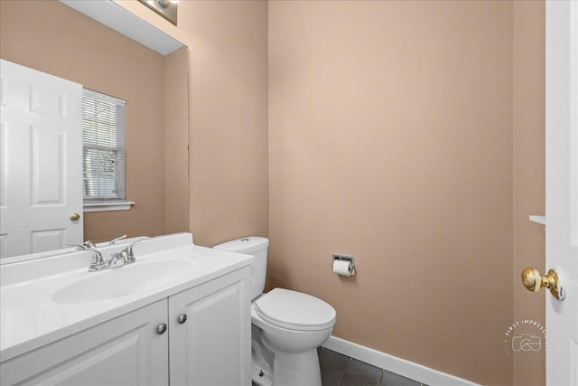 half bath with vanity, toilet, baseboards, and tile patterned flooring