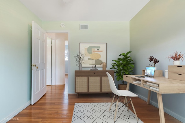 home office featuring visible vents, baseboards, and wood finished floors