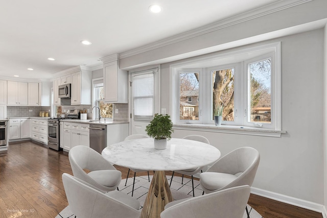 dining room with dark wood-style floors, baseboards, and a healthy amount of sunlight