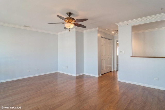 spare room with visible vents, crown molding, ceiling fan, baseboards, and wood finished floors