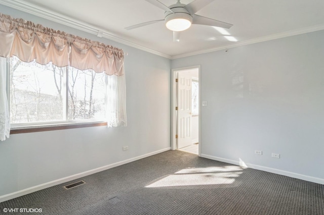 carpeted spare room featuring visible vents, a ceiling fan, baseboards, and ornamental molding
