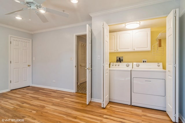 laundry area featuring ornamental molding, cabinet space, light wood-style floors, and washing machine and clothes dryer