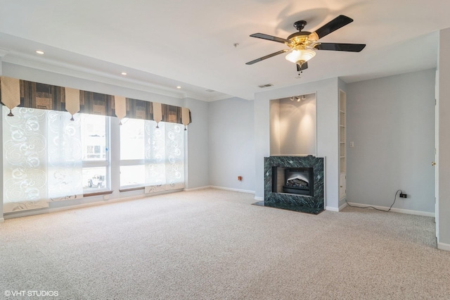 unfurnished living room with visible vents, baseboards, recessed lighting, a high end fireplace, and carpet flooring