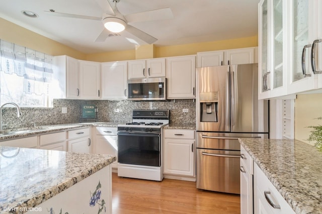 kitchen with a sink, appliances with stainless steel finishes, and white cabinets