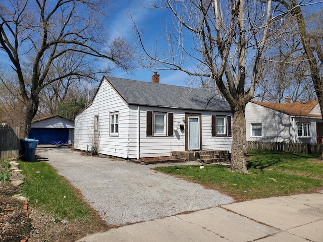 818 Campbell Ave, Calumet City, IL 60409 - bungalow featuring an outbuilding, a detached garage, roof with shingles, fence, and a chimney