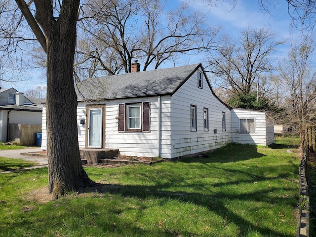 818 Campbell Ave, Calumet City, IL 60409 - exterior space with a front lawn, a shingled roof, and a chimney
