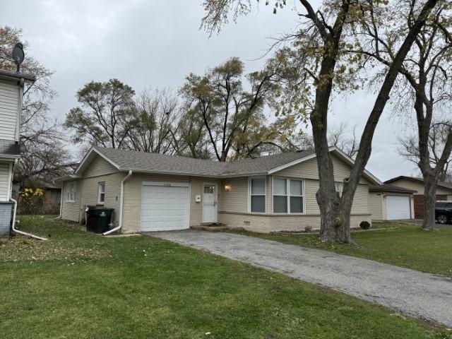 single story home with aphalt driveway, a garage, and a front yard