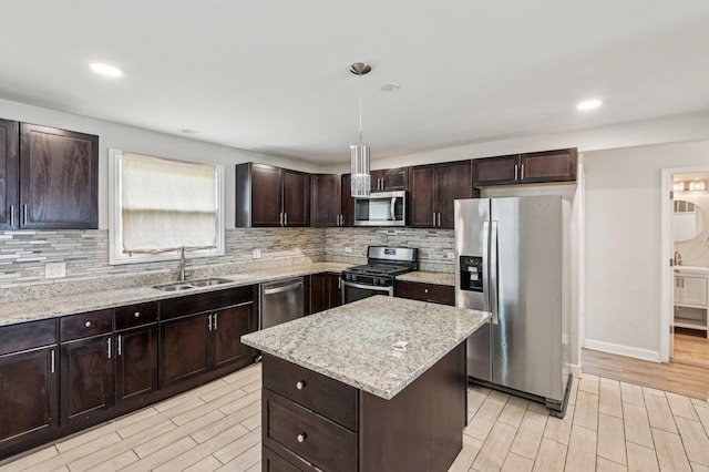 kitchen featuring decorative backsplash, light wood-style flooring, stainless steel appliances, and a sink