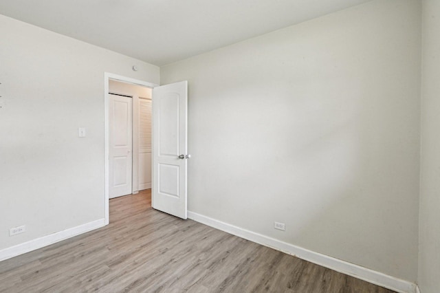 spare room with light wood-style flooring and baseboards