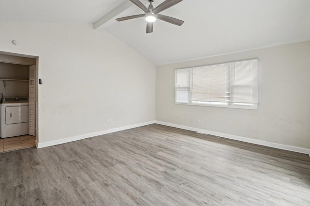 empty room featuring a ceiling fan, wood finished floors, lofted ceiling with beams, baseboards, and washer / clothes dryer