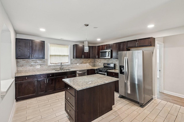 kitchen with backsplash, light wood-type flooring, appliances with stainless steel finishes, and a sink