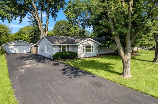 ranch-style home with a detached garage, an outdoor structure, and a front yard