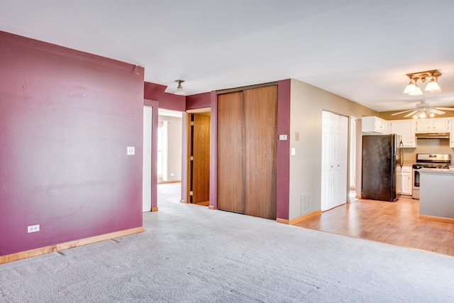 interior space featuring a ceiling fan, baseboards, visible vents, and light carpet