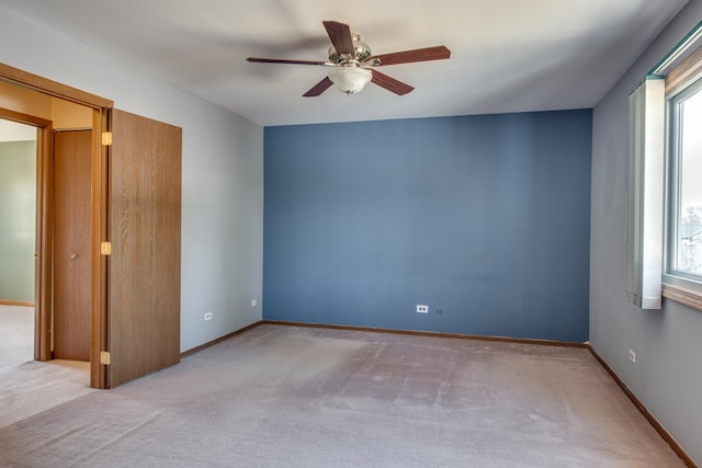 empty room with plenty of natural light, baseboards, carpet floors, and ceiling fan