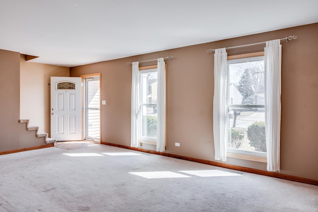 carpeted empty room featuring plenty of natural light and baseboards