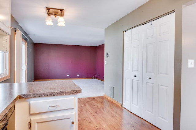 kitchen with visible vents, light countertops, light wood-type flooring, and baseboards