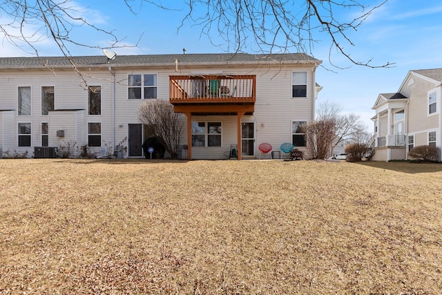 back of property featuring central air condition unit and a lawn