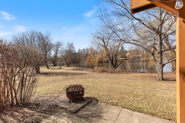 view of yard featuring a water view and an outdoor fire pit