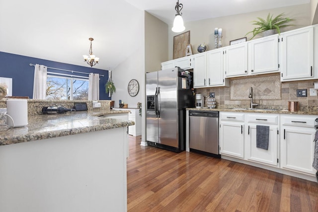 kitchen featuring a sink, appliances with stainless steel finishes, pendant lighting, and white cabinetry