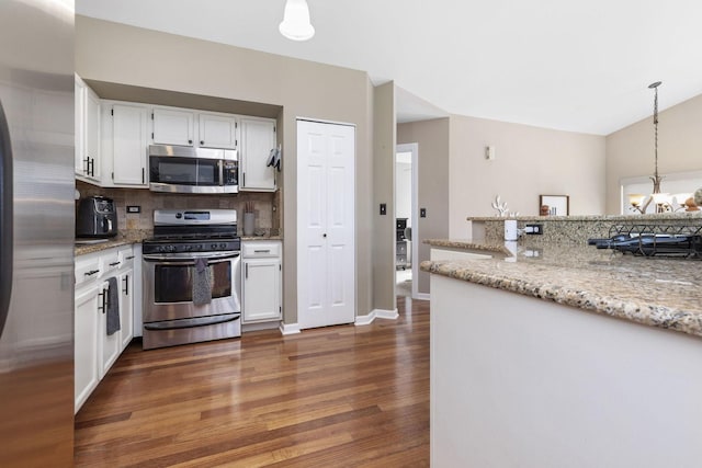 kitchen with stainless steel appliances, a chandelier, dark wood finished floors, and white cabinetry