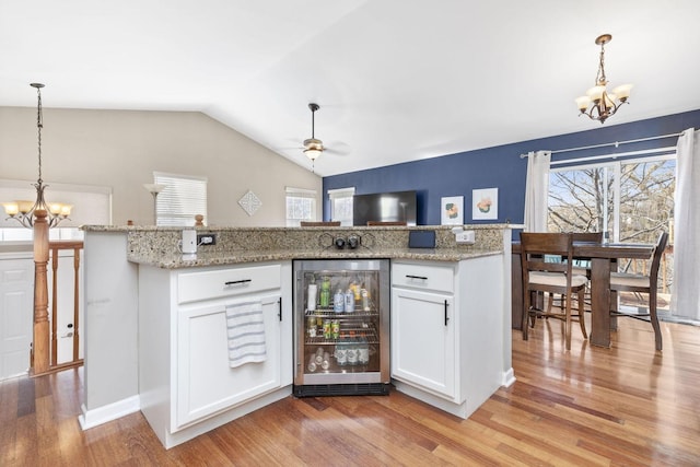 kitchen featuring wine cooler, a healthy amount of sunlight, and light wood-style floors