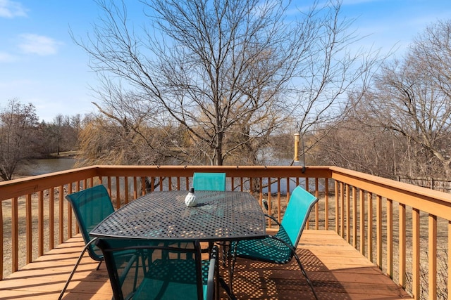 wooden deck with outdoor dining area and a water view