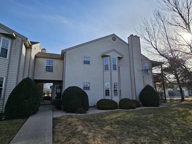 view of property exterior with a yard and a chimney