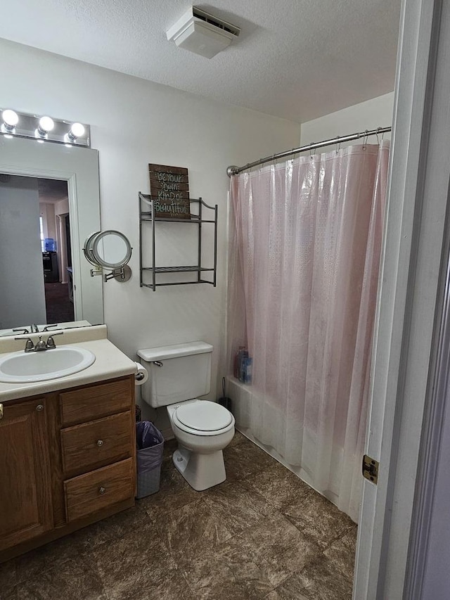 bathroom featuring vanity, toilet, visible vents, and a textured ceiling