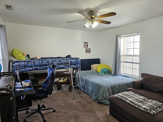 carpeted bedroom featuring a ceiling fan and visible vents