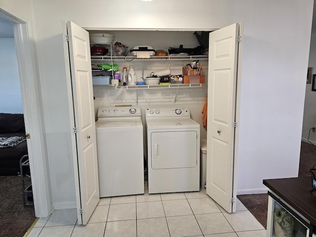 laundry area with independent washer and dryer, light tile patterned flooring, and laundry area