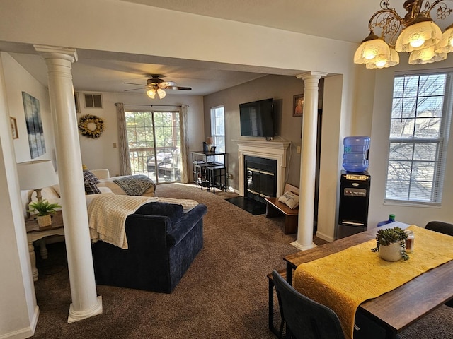 living area with visible vents, a fireplace with flush hearth, a ceiling fan, carpet flooring, and decorative columns