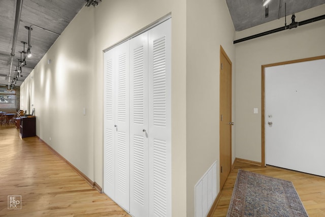 hallway with visible vents, wood finished floors, and track lighting