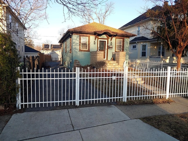 bungalow-style home with a fenced front yard and stucco siding