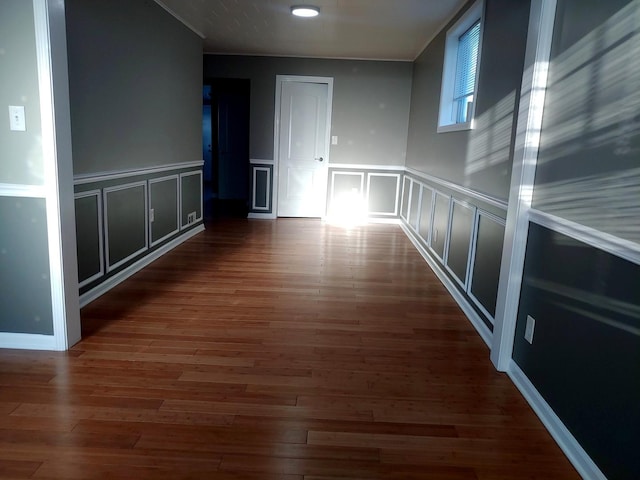 spare room with a decorative wall and wood finished floors