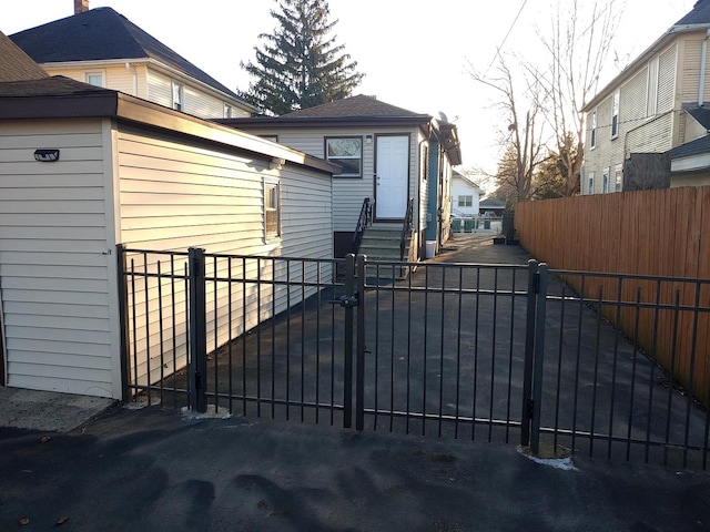 rear view of house with a gate, fence, and entry steps