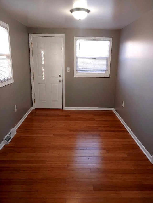 entryway featuring visible vents, baseboards, and wood finished floors