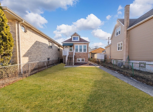 rear view of house with a yard, a fenced backyard, and brick siding