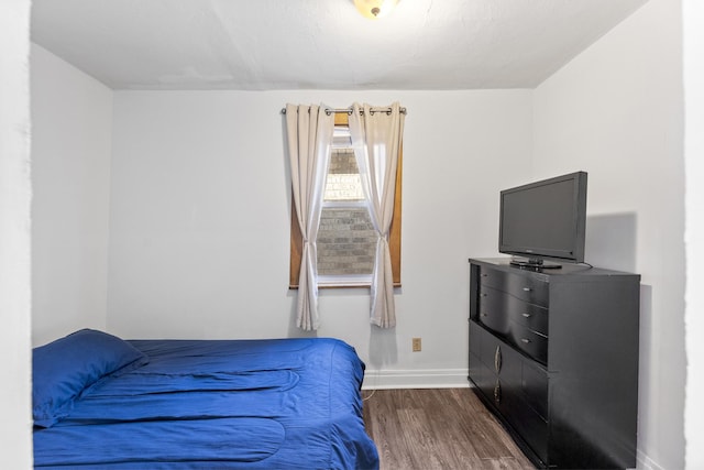 bedroom with dark wood-style floors and baseboards