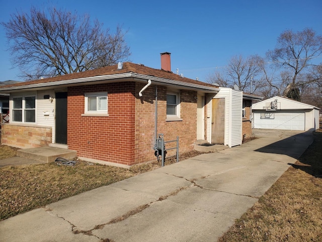 view of home's exterior with an outdoor structure, a garage, brick siding, and a chimney