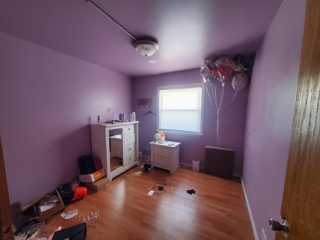 bedroom featuring baseboards and wood finished floors