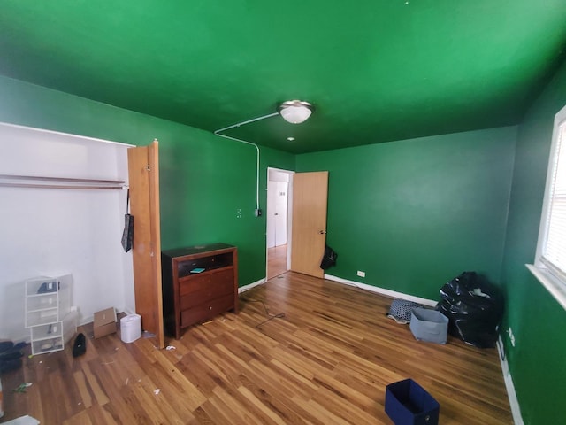 bedroom with baseboards and wood finished floors