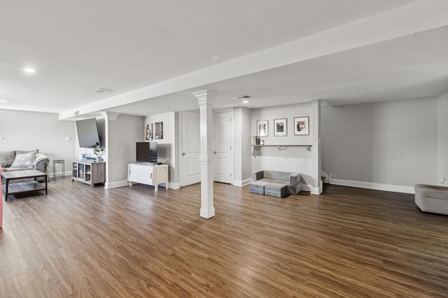 living room with visible vents, baseboards, and wood finished floors