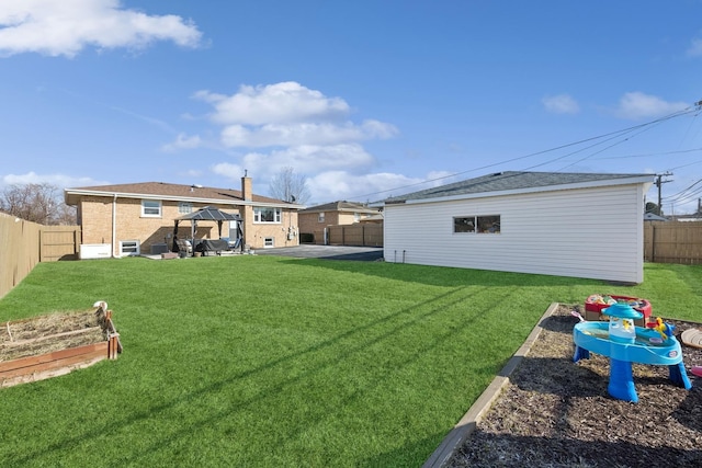 view of yard featuring a patio, a vegetable garden, and a fenced backyard